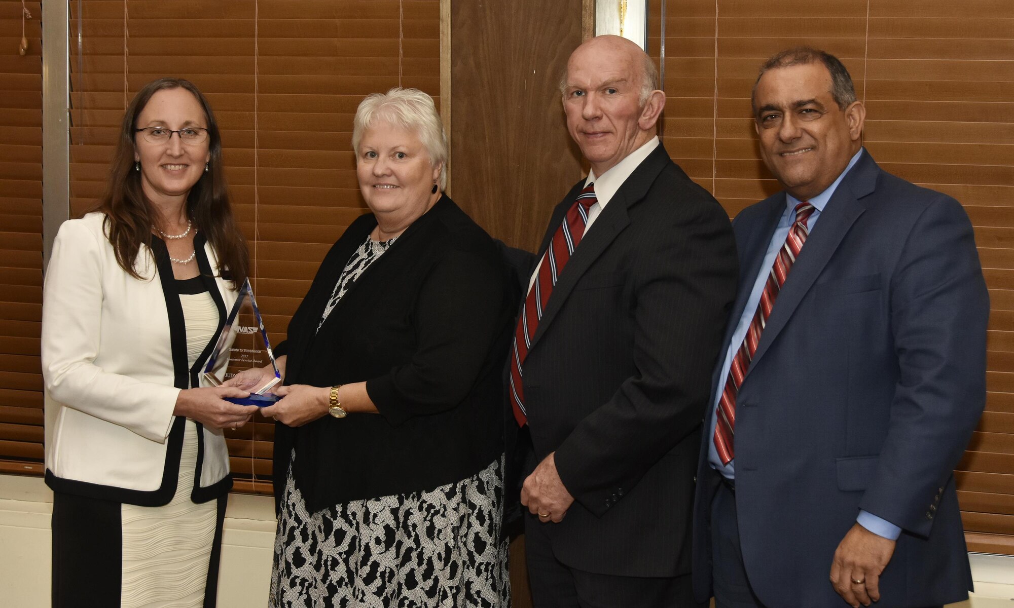 Judy Brewer (second from left), NAS administrative assistant, receives the Customer Service Award from NAS General Manager Cynthia Rivera during the National Aerospace Solutions 2017 Salute to Excellence Annual Awards Banquet held Nov. 16 at the Arnold Lakeside Center, Arnold Air Force Base, Tenn.. NAS Deputy General Manager Doug Pearson and NAS Business Services Manager Miguel Lugo are pictured at right. (U.S. Air Force photo/Rick Goodfriend)