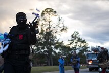 Airman 1st Class Brandon Adler, 23d Logistic Readiness Squadron material management technician, throws candy during a parade at the Tree Lighting Ceremony, Dec. 1, 2017, at Moody Air Force Base, Ga. The annual event brings the base community together as a way to show thanks for their continuous sacrifice and celebrate the holiday season. The celebration included a parade, raffle give-a-ways, children’s activities and traditional lighting of the base Christmas tree by families of deployed Airmen. (U.S. Air Force photo by Airman 1st Class Erick Requadt)
