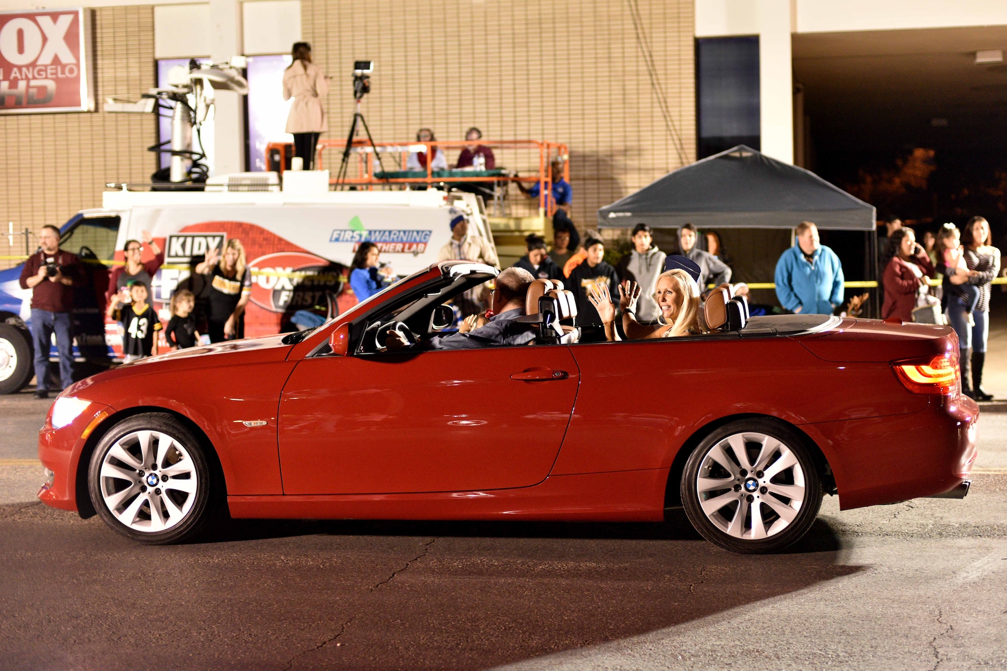 Megan Mills, wife of U.S. Air Force Col. Ricky Mills, 17th Training Wing commander, waves to participants during the 17th annual Lights of Christmas Parade in San Angelo, Texas, Dec. 2, 2017. Multiple churches, businesses, organizations, clubs and schools decorated trucks, trailers and floats for the Concho Christmas celebration. (U.S Air Force Photo by Airman 1st Class Randall Moose/Released)