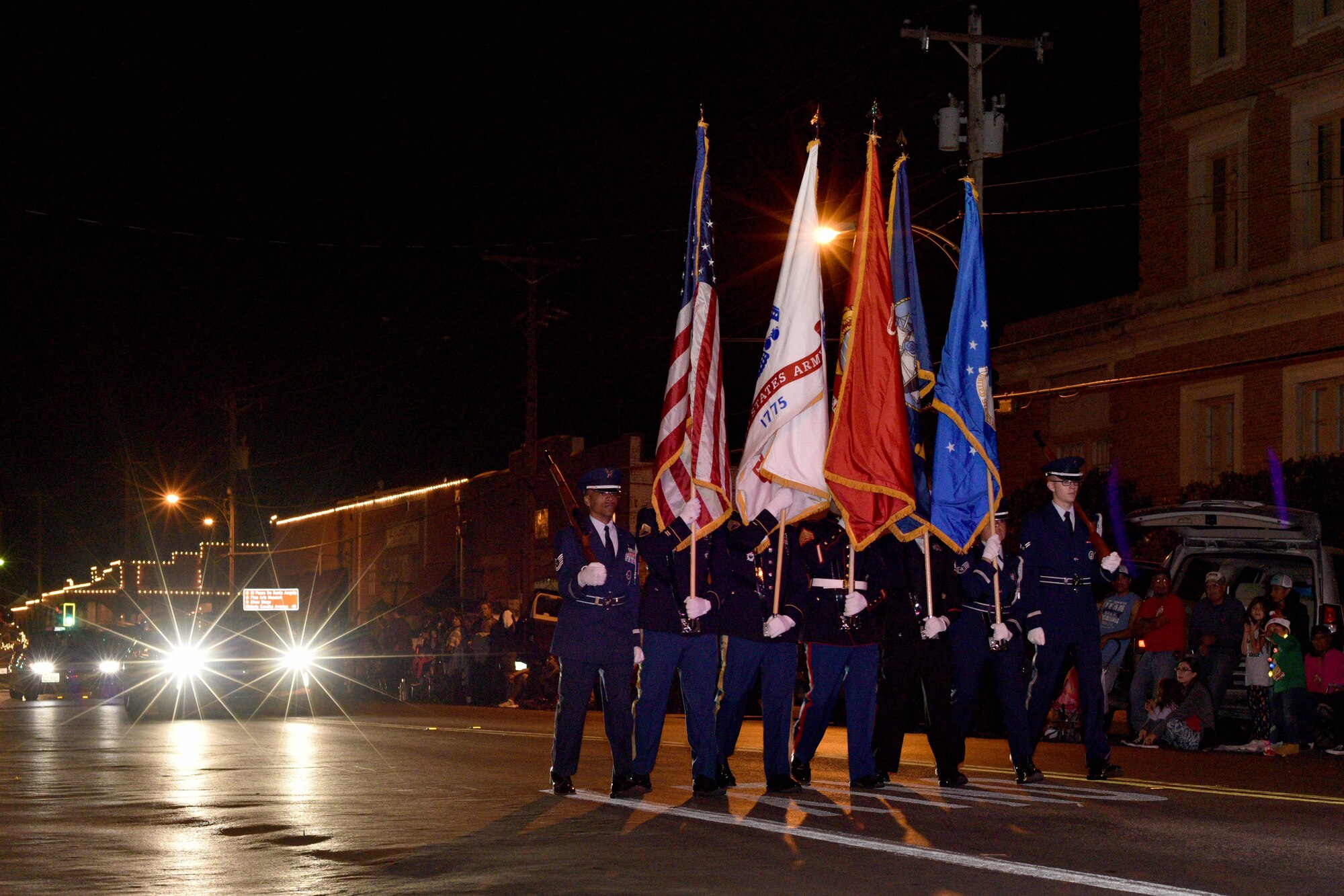 Goodfellow Color Guard marches during the 17th annual Lights of Christmas Parade in San Angelo, Texas, Dec. 2, 2017. Goodfellow Air Force Base led the 17th annual Lights of Christmas Parade through downtown San Angelo. The Goodfellow color guard was followed by U.S. Air Force Col. Ricky Mills, 17th Training Wing commander, and his wife Megan Mills. U.S Air Force Photo by Airman 1st Class Randall Moose/Released)