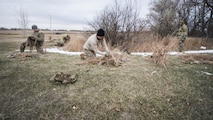 Defenders from the 791st Missile Security Forces Squadron sew foliage on to their ghillie suits during joint-unit training at Minot Air Force Base, N.D., Nov. 22, 2017. During training, Airmen added natural elements such as sticks and grass to their camouflage suits to better integrate themselves in a variety of locations. (U.S. Air Force photo by Senior Airman J.T. Armstrong)