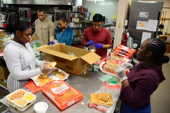 Airmen from the 341st Force Support Squadron separate rolls into individual bags for Meals on Wheels Nov. 22, 2017, in Great Falls, Mont. Airmen helped disperse nearly 600 meals delivered for the Thanksgiving holiday. (U.S. Air Force photo by Airman 1st Class Tristan Truesdell)