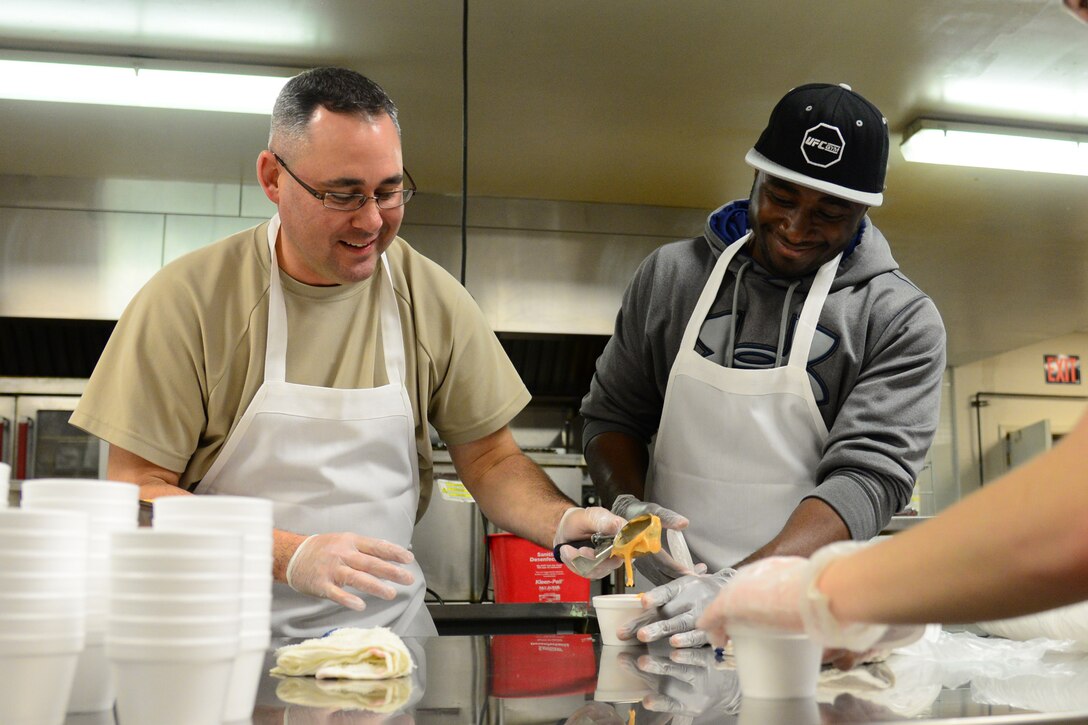 (Left) Master Sgt. Paul Watts, 341st Civil Engineer Squadron first sergeant, and Staff Sgt. Moses Adenolda, 341st Security Forces Squadron command support staff, cup butterscotch pudding for Meals on Wheels Nov. 22, 2017, in Great Falls, Mont. Desserts are provided with each meal prepared for the Thanksgiving holiday. (U.S. Air Force photo by Airman 1st Class Tristan Truesdell)