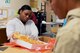 Airman 1st Class Destini Vance, 341st Force Support Squadron customer support apprentice, pulls rolls out of a box during Meals on Wheels meal preparation Nov. 22, 2017, in Great Falls, Mont. Food is divided into single-person servings for proper nutrition. (U.S. Air Force photo by Airman 1st Class Tristan Truesdell)
