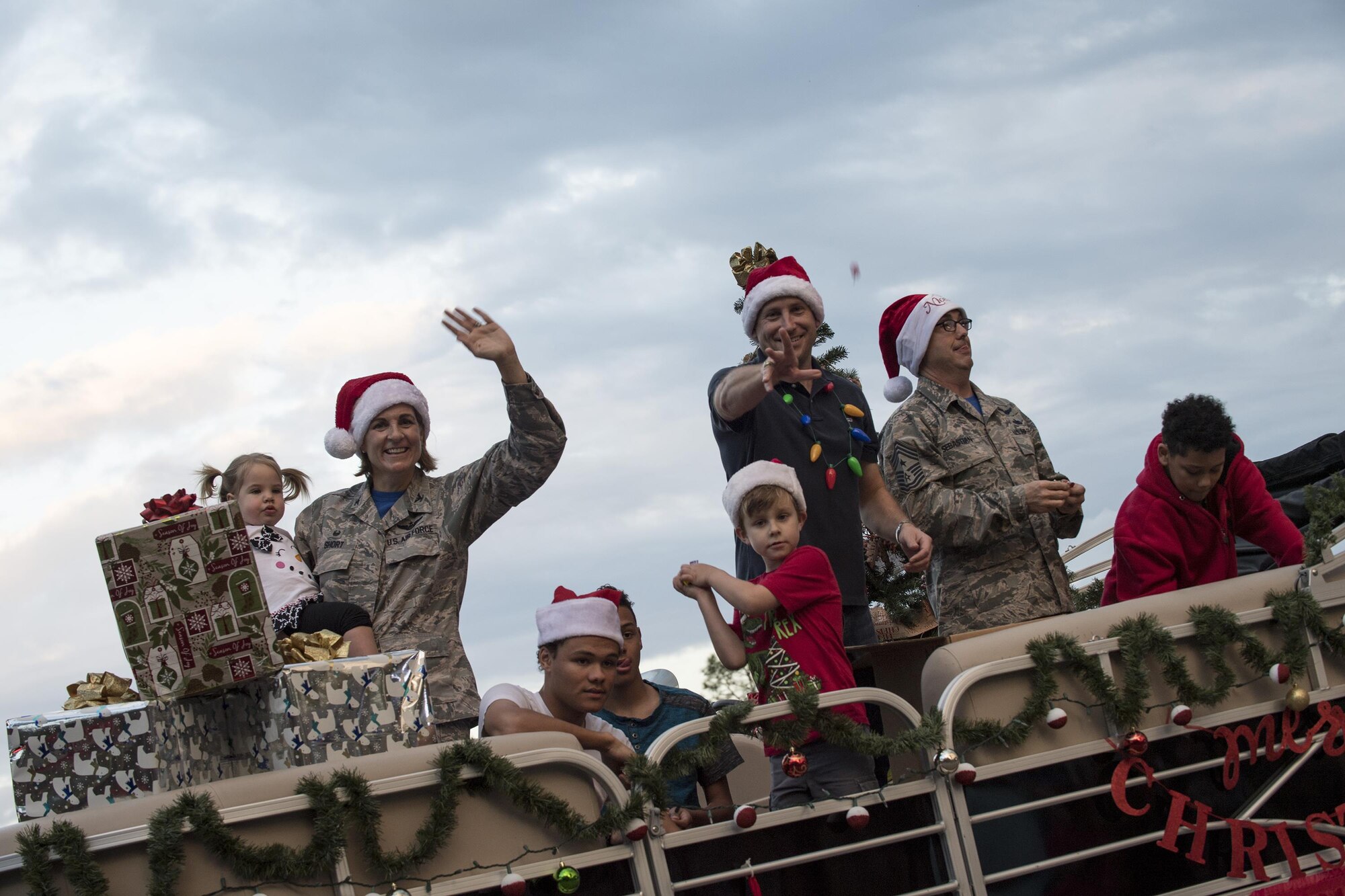 Col. Jennifer Short, 23d Wing commander, Chief Master Sgt. Jarrod Sebastian, 23d Wing command chief, and their families throw candy during a parade at the Tree Lighting Ceremony, Dec. 1, 2017, at Moody Air Force Base, Ga. The annual event brings the base community together as a way to show thanks for their continuous sacrifice and celebrate the holiday season. The celebration included a parade, raffle give-a-ways, children’s activities and traditional lighting of the base Christmas tree by families of deployed Airmen. (U.S. Air Force photo by Andrea Jenkins)