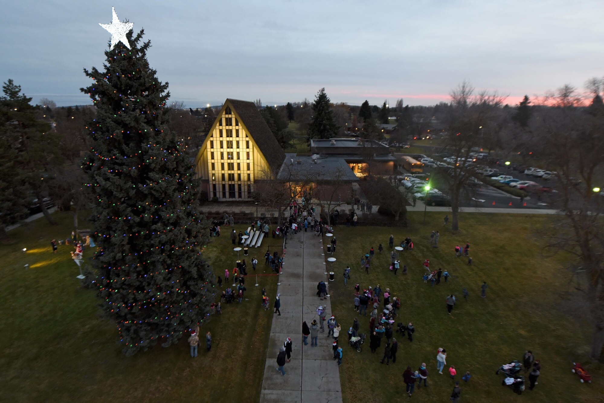 Team Fairchild gathers in front of the base chapel for the annual Holiday Tree Lighting Ceremony Dec. 1, 2017, at Fairchild Air Force Base, Washington. Santa Claus joined Team Fairchild and their families at the chapel for caroling, cookies, hot chocolate and the lighting of the holiday tree. (U.S. Air Force photo/Airman Whitney Laine)
