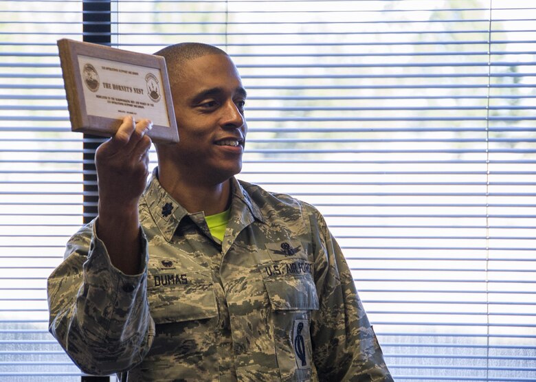 Lt. Col. Kelvin Dumas, 310th Space Operations Squadron commander, holds up the official plaque assigning a name to the new 310th OSS classroom on Friday, Dec. 1st, 2017.