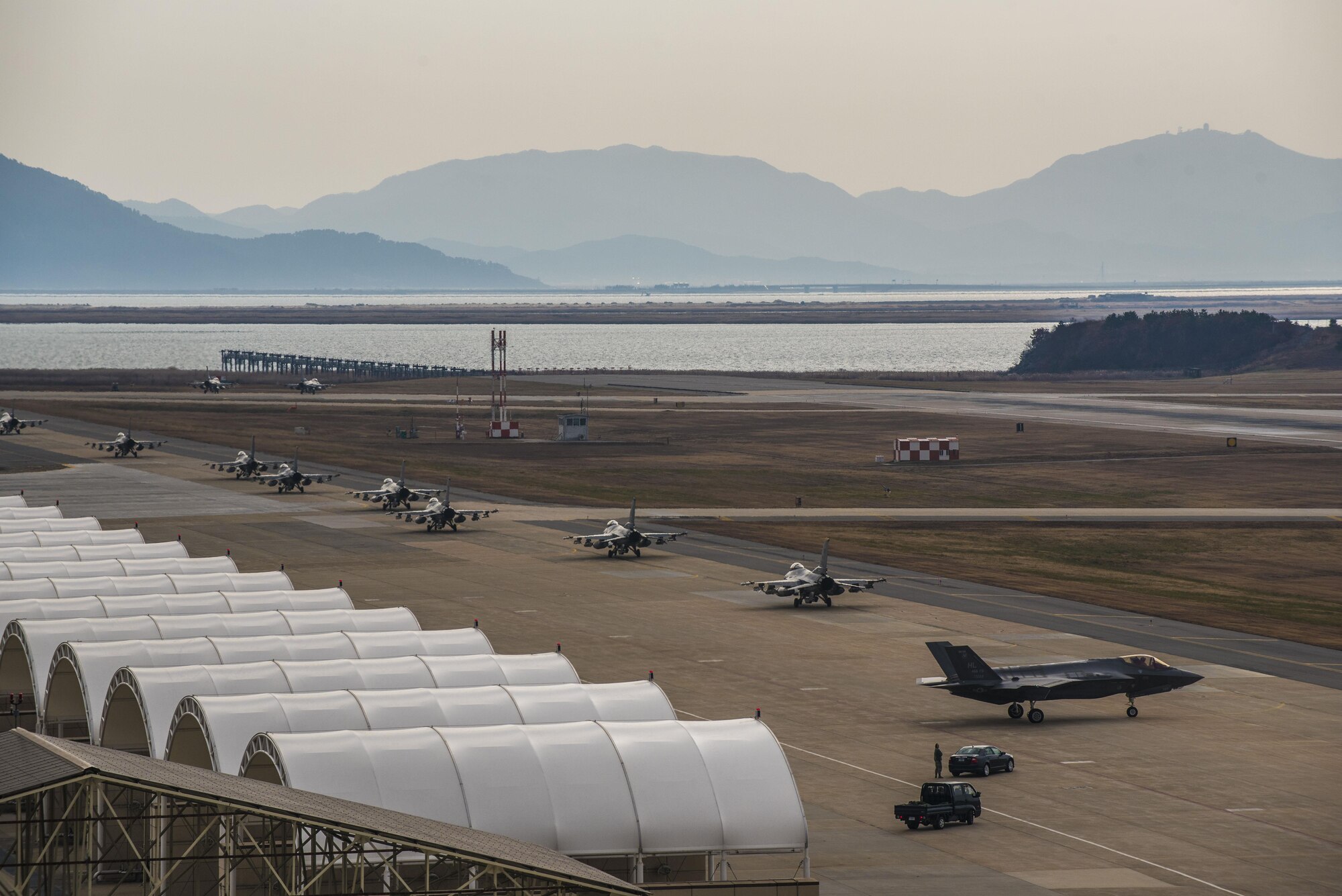 U.S. Air Force F-16 Fighting Falcons assigned to the 8th Fighter Wing taxi in front of an F-35A Lightning II assigned to Hill Air Force Base, Utah at Kunsan Air Base, Republic of Korea, Dec. 3, 2017. The 8th Fighter Wing hosted the fifth-generation strike fighters to train side-by-side during the week-long, bi-annual exercise VIGILANT ACE 18. (U.S. Air Force photo by Master Sgt. Frank W. Miller III)