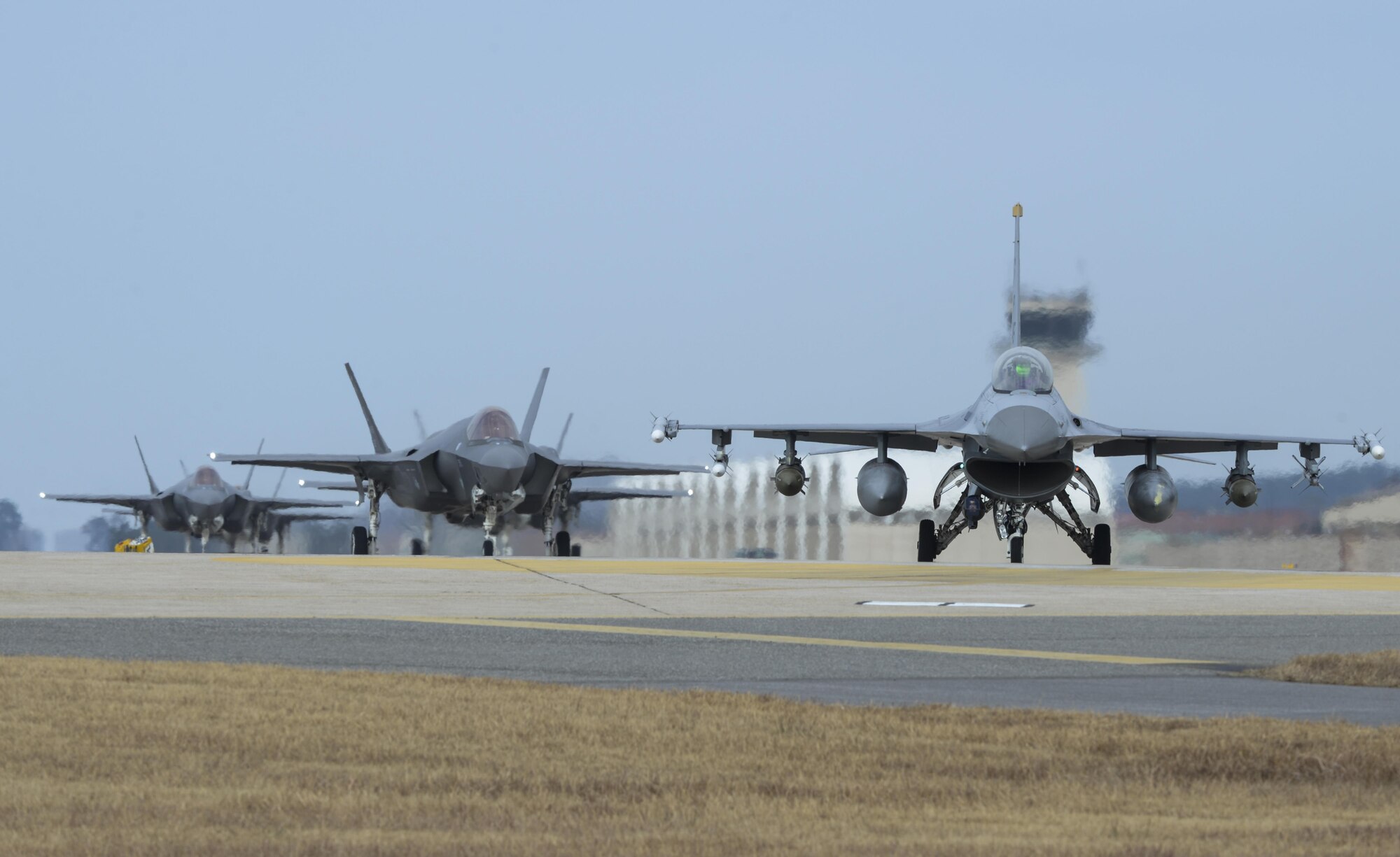 A U.S. Air Force F-16 Fighting Falcon and four F-35A Lightning IIs assigned to the 34th Expeditionary Fighter Squadron Hill Air Force Base, Utah, taxi toward the end of the runway during exercise VIGILANT ACE 18, Dec. 3, 2017, at Kunsan Air Base, Republic of Korea. The Airmen from the 34th EFS deployed to Kadena Air Base, Japan in October, and sent Airmen and aircraft to participate in the week-long, annual VIGILANT ACE exercise in support of the Mutual Defense Treaty between the U.S. and Republic of Korea. (U.S. Air Force photo by Senior Airman Colby Hardin)