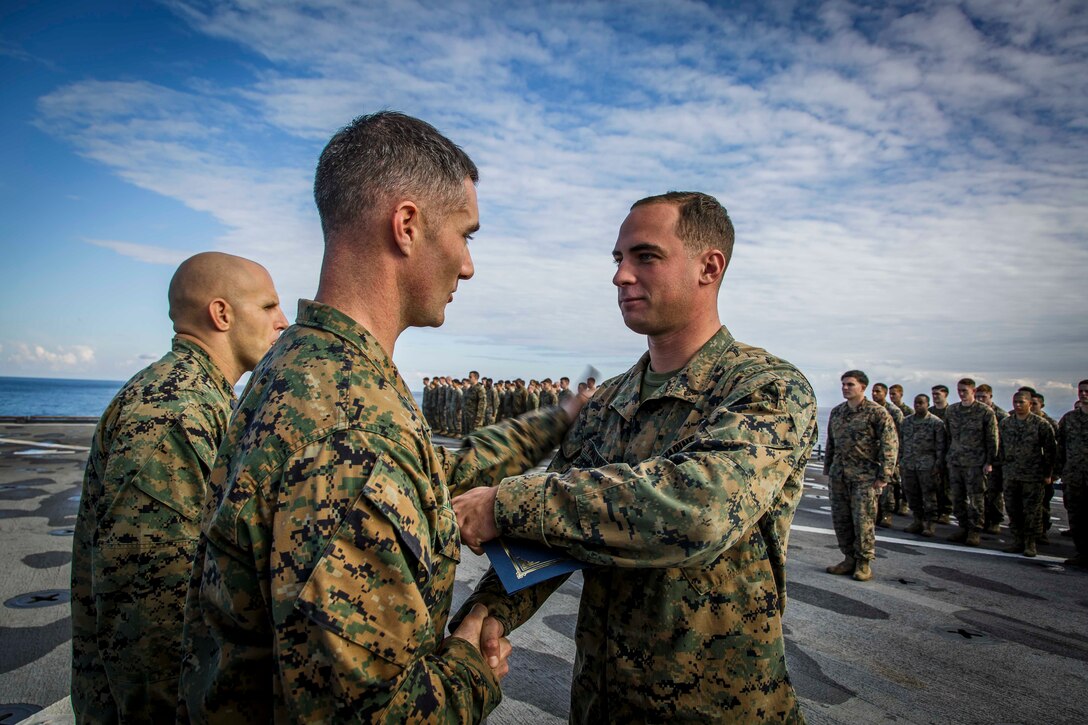 U.S. Marine Corps Cpl. Anthony C. Panzarella , right, an infantry Marine with Fox Company, Battalion Landing Team, 2nd Battalion, 6th Marine Regiment, 26th Marine Expeditionary Unit (MEU), receives his meritorious promotion warrant from Capt. Joseph Murphy, left, commanding officer of Fox Co., BLT/2/6, 26th MEU, during a ceremony aboard the dock landing ship USS Oak Hill (LSD 51) in the Atlantic Ocean, Dec. 1, 2017, during Combined Composite Training Unit Exercise (COMPTUEX). Combined COMPTUEX allows all elements of the Marine Air Ground Task Force to join and train in realistic scenarios so the MEU as a whole can meet its Predeployment Training Program objectives prior to an upcoming deployment at sea. (U.S. Marine Corps photo by Staff Sgt. Dengrier M. Baez)