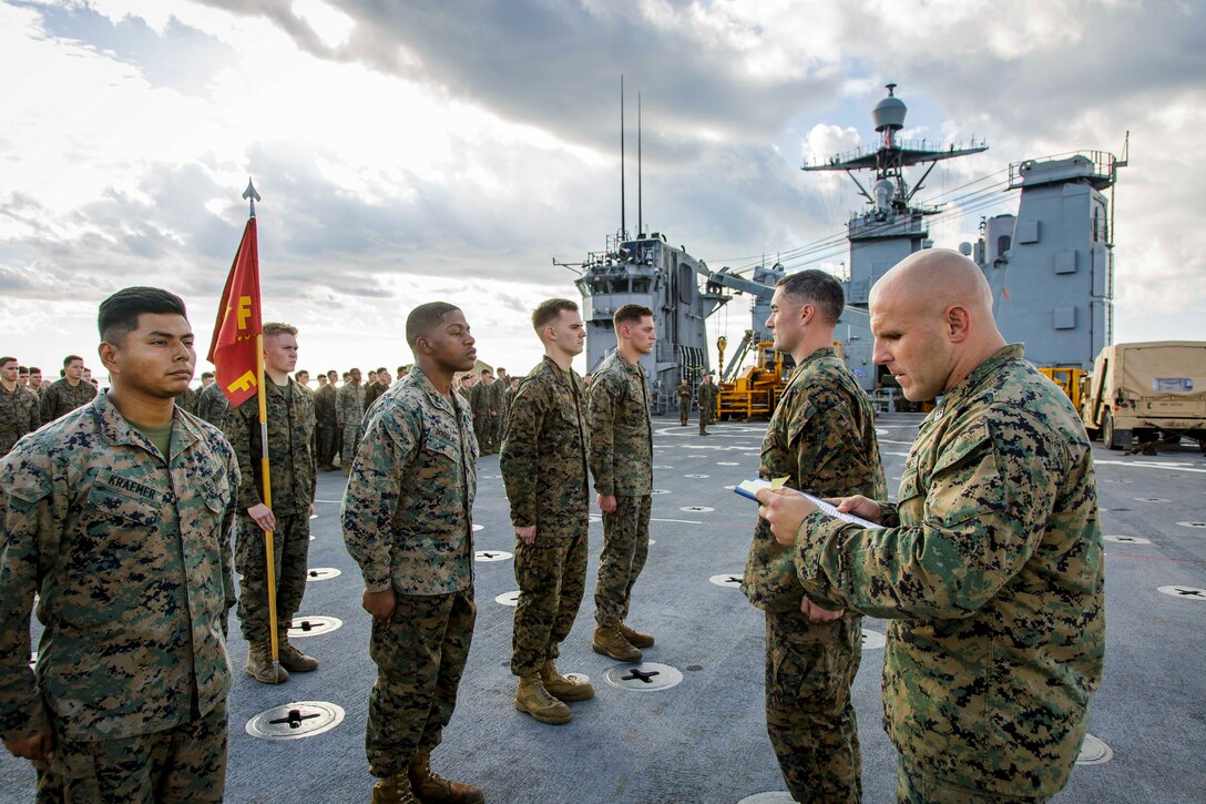 U.S. Marine Corps 1st Sgt. Christian Appleman, first sergeant of Fox Company, Battalion Landing Team, 2nd Battalion, 6th Marine Regiment, 26th Marine Expeditionary Unit (MEU) and senior enlisted advisor of troops aboard the dock landing ship USS Oak Hill (LSD 51), reads promotion warrants during a ceremony aboard the Oak Hill in the Atlantic Ocean, Dec. 1, 2017, during Combined Composite Training Unit Exercise (COMPTUEX). Combined COMPTUEX allows all elements of the Marine Air Ground Task Force to join and train in realistic scenarios so the MEU as a whole can meet its Predeployment Training Program objectives prior to an upcoming deployment at sea. (U.S. Marine Corps photo by Staff Sgt. Dengrier M. Baez)