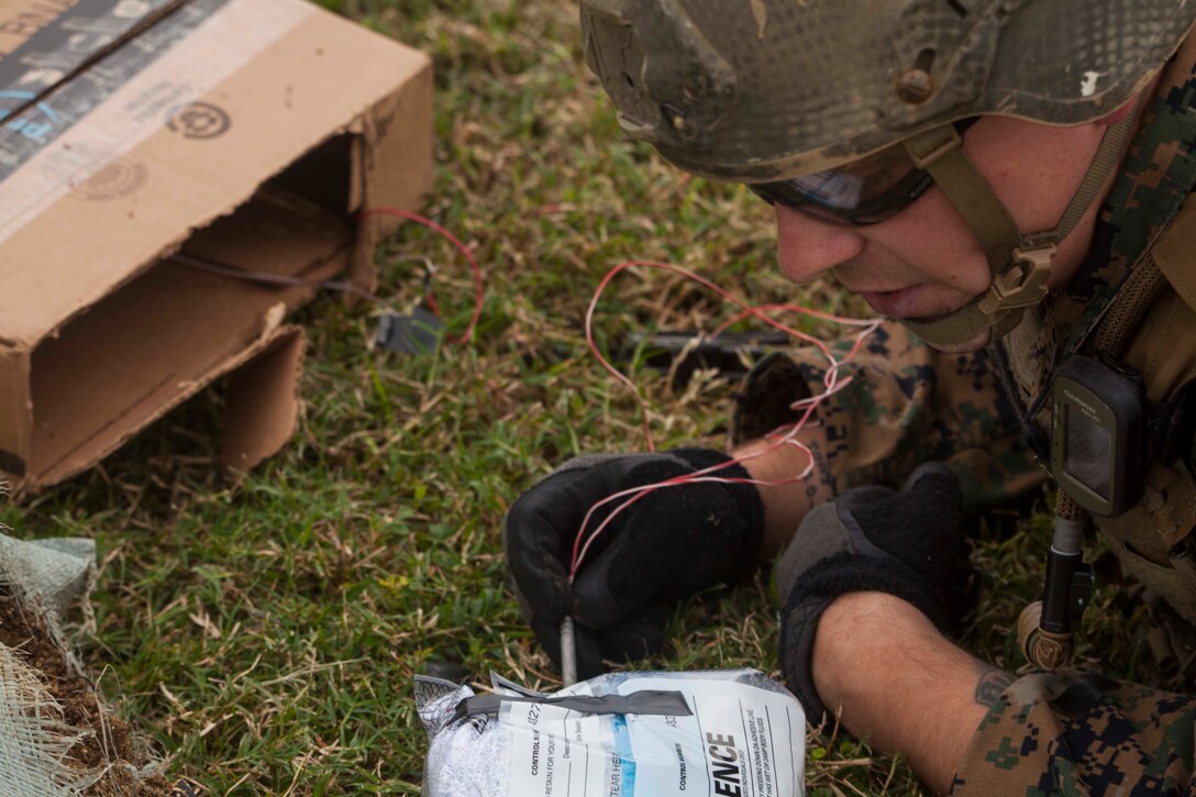 Staff Sgt. Cody Fazio, an explosive ordnance disposal technician with Combat Logistics Battalion 31, inspects a disassembled improvised explosive device during counter-IED training at Camp Hansen, Okinawa, Japan, Nov. 22, 2017.