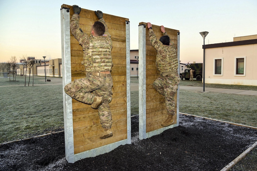 Two soldiers scale wall sections side by side.