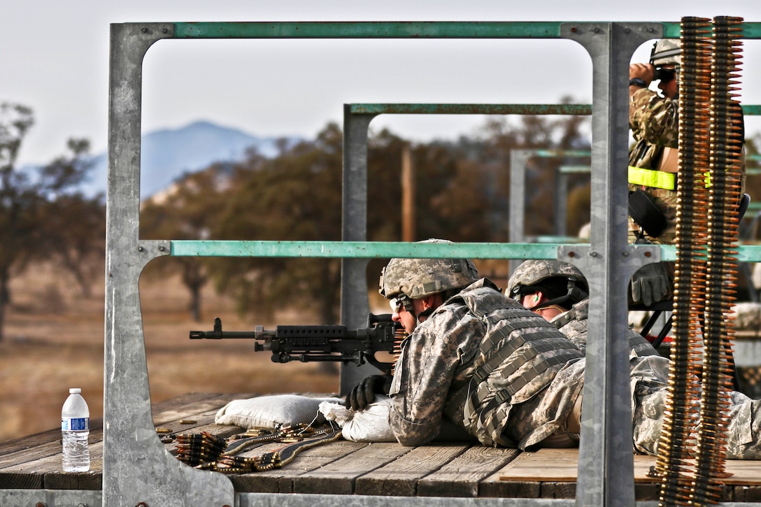 1st Lt. Zachary Wenzel, foreground, observes his gunner fire an M240B machine gun during weapon qualification.