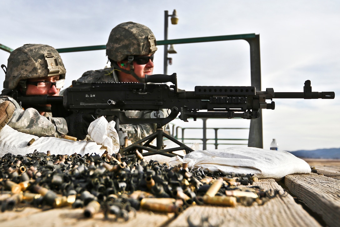 1st Lt. Zachary Wenzel, left, and Pfc. Dustin Poszywak work together as gunner and assistant gunner to qualify on an M240B machine gun.