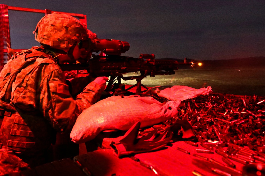 Spcs. Timothy Dauser and Christopher Landon work together as gunner and assistant gunner to qualify on an M240B machine gun.