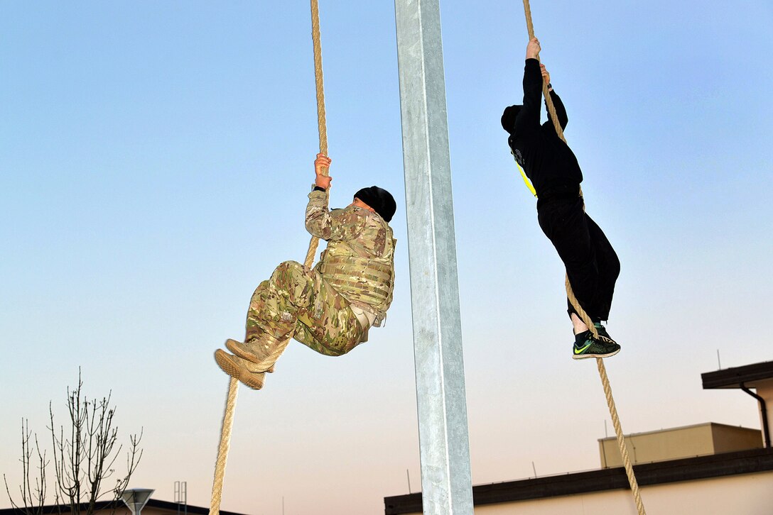 Soldiers participate in the rope climbing event during physical training.