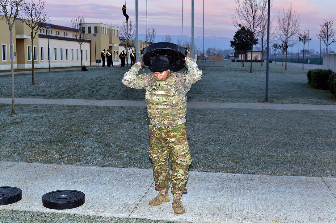 A soldier lifts a heavy weights in the strengthening event during physical training.