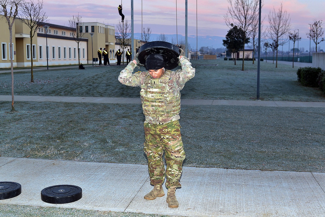 A soldier lifts a heavy weights in the strengthening event during physical training.