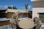National Guard Soldiers from New Mexico finish assembling a satellite communications system on the roof of the military police headquarters in Vieques, Puerto Rico, on Dec. 1, 2017.  Soldiers brought the system to the island to enhance communications between Army units stationed on Vieques and those back on mainland Puerto Rico.
