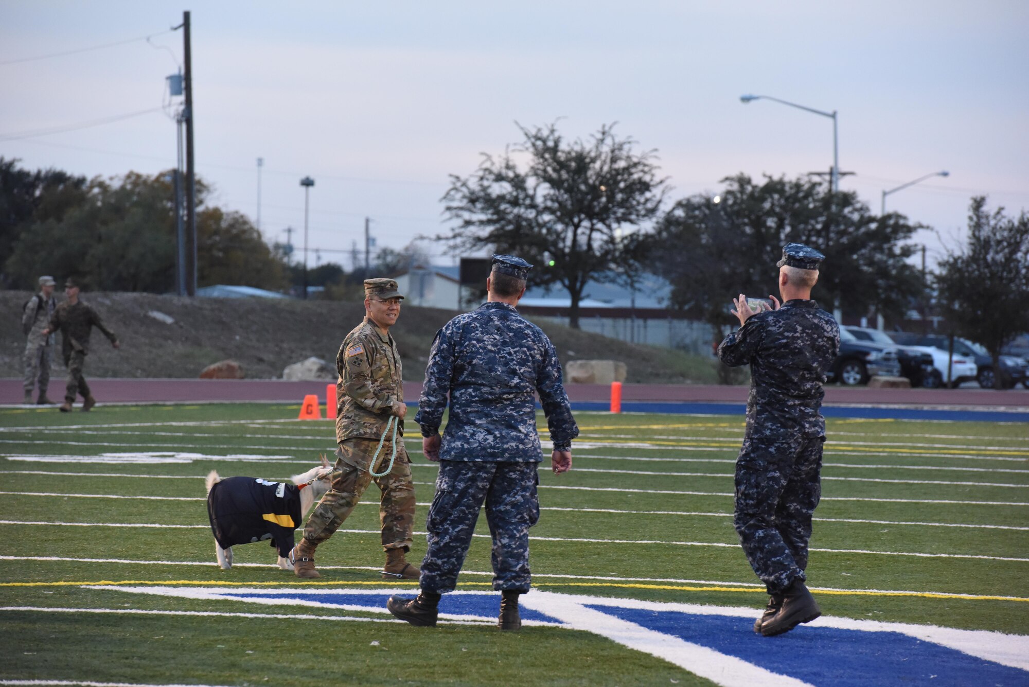 U.S. Army Lt. Col. Yukio Kuniyuki, 344th Military Intelligence Battalion commander, walks Marshmallow around after the Army-Navy game at the Mathis Fitness Center field, Dec. 1. Marshmallow is the mascot of the Navy team, the losing team had to take a walk with the winning team’s mascot before everyone. (U.S. Air Force photo by Airman 1st Class Zachary Chapman/Released)