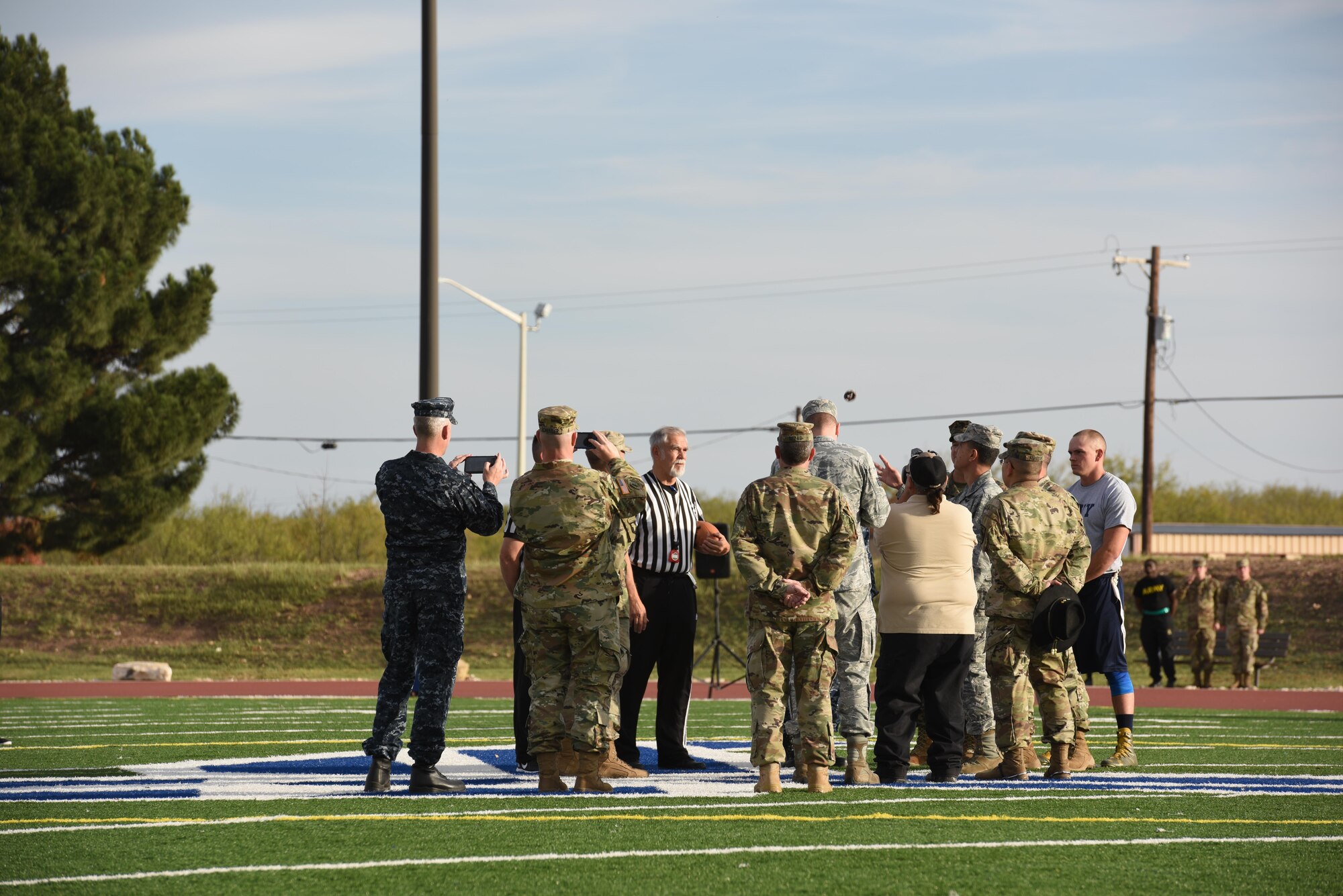 U.S. Air Force Col. Ricky Mills, 17th Training Wing commander, flips the coin determining who will go first during the Army-Navy game at the Mathis Fitness Center field Dec. 1. As honored guest, along with tossing the coin, Mills gave opening remarks before the game on the translation of comradery from on the playing field to on the battle field. (U.S. Air Force photo by Airman 1st Class Zachary Chapman/Released)