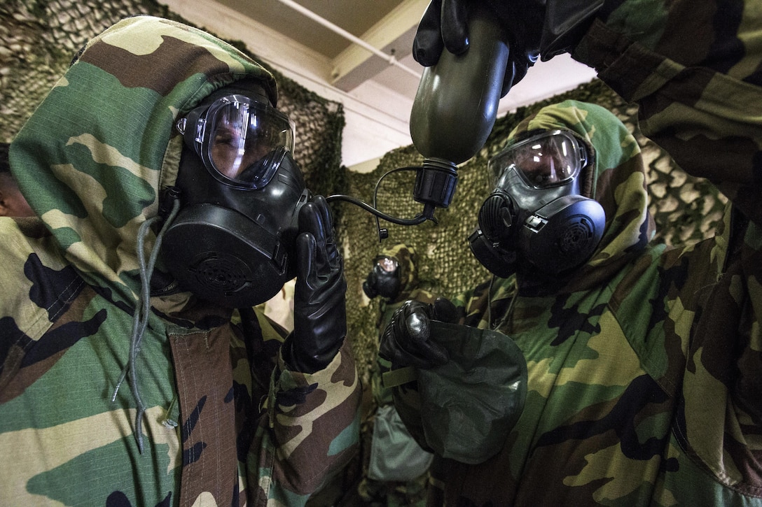 Airmen practice drinking from a canteen wearing Mission Oriented Protective Posture gear