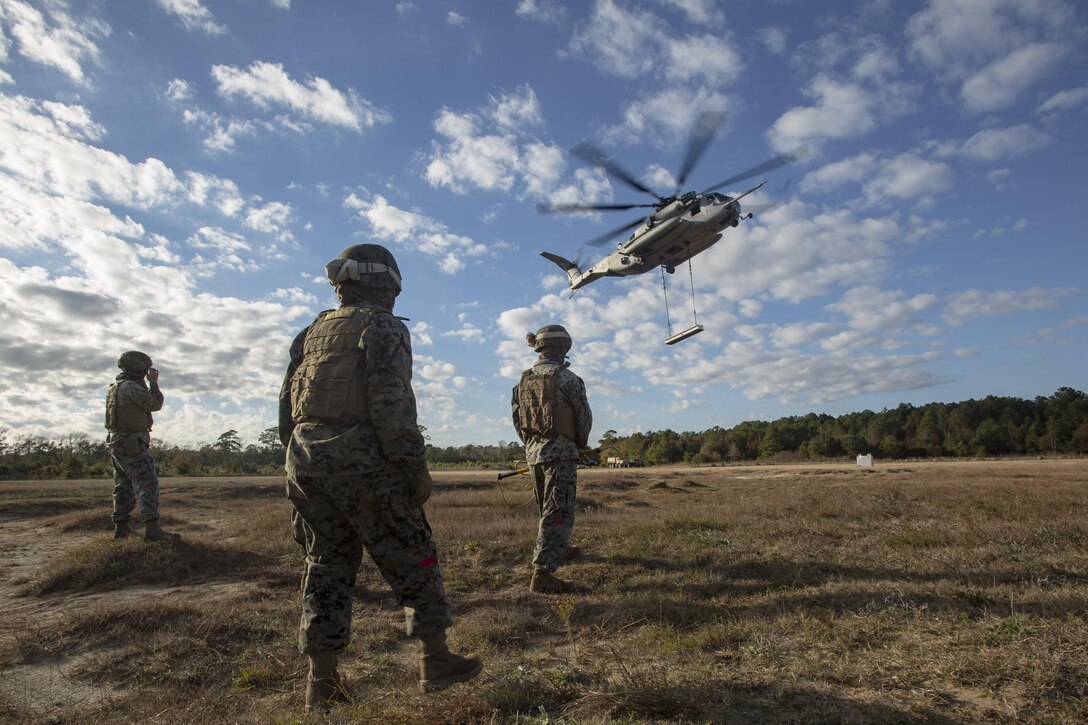 Marines with Combat Logistics Battalion 6, 2nd Marine Logistics Group observe a CH-53E Super Stallion during Helicopter Support Team training at Camp Lejeune, N.C., Nov. 28, 2017. A Helicopter Support Team is comprised of approximately eight landing support specialist Marines who ensure the equipment is properly attached and secured before pilots transport the gear or supplies to their destination. (U.S. Marine Corps photo by Cpl. Aaron Henson)