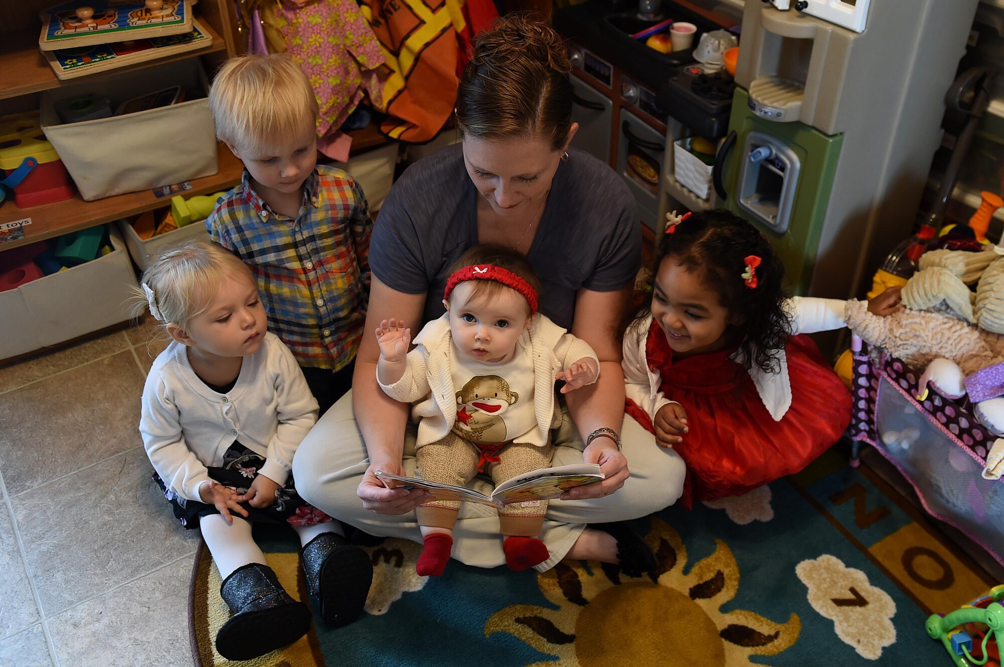 Woman reads book to group of children