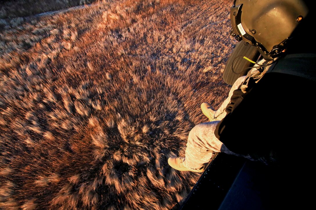 Sgt. Jeff Angle observes the ground from his UH-60 Black Hawk helicopter during a training exercise.