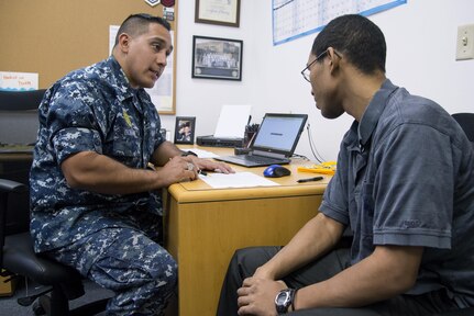 Petty Officer First Class Christopher Thomas, Navy Recruiting District San Antonio recruiter, speaks to an applicant about job opportunities in the Navy Oct. 25, 2017.  Thomas’ mission is to find officer applicants to lead naval forces in conducting operations on land, air and sea.  (U.S. Air Force photo by Sean M. Worrell)