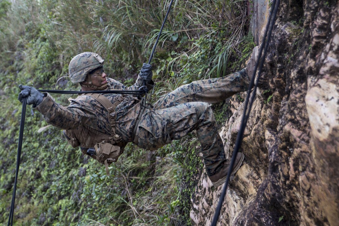 A Marine rappels down a cliff during a competition.