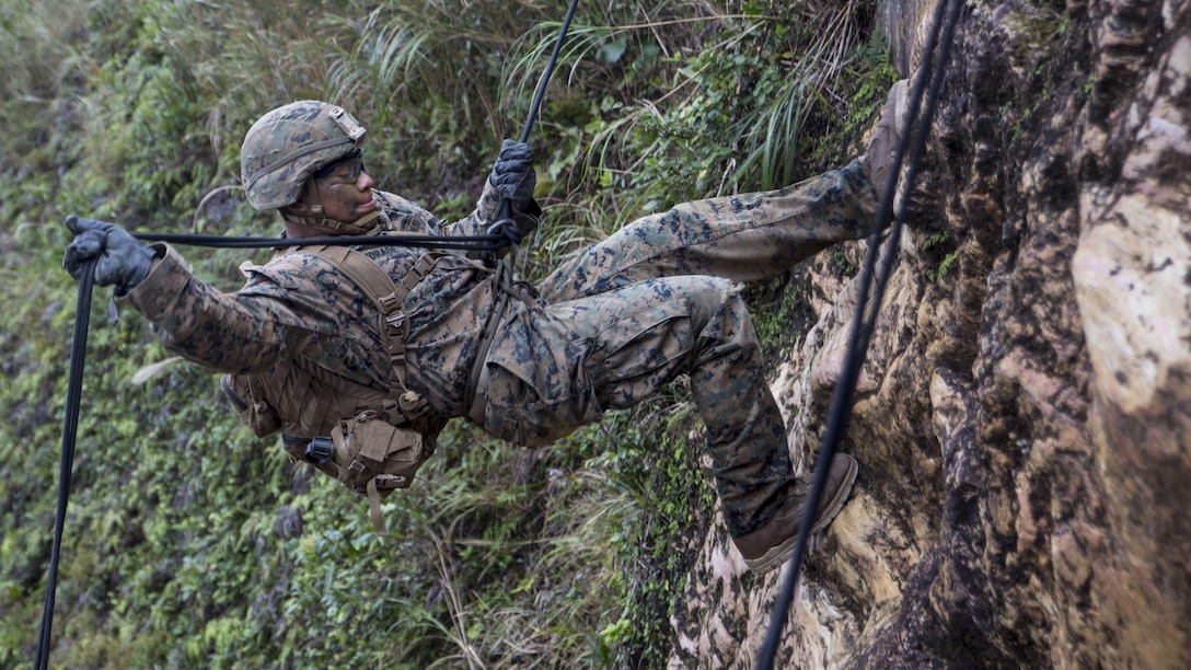 A Marine rappels down a cliff during a competition.