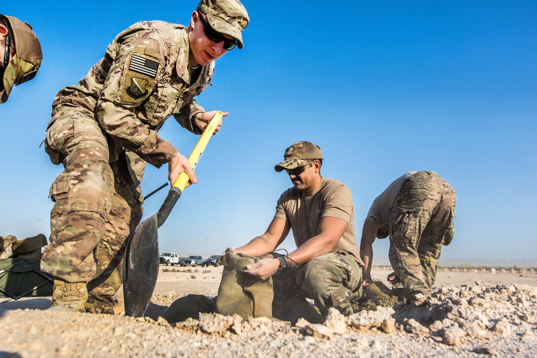 Airmen fill sand bags during a joint chemical threat training exercise.