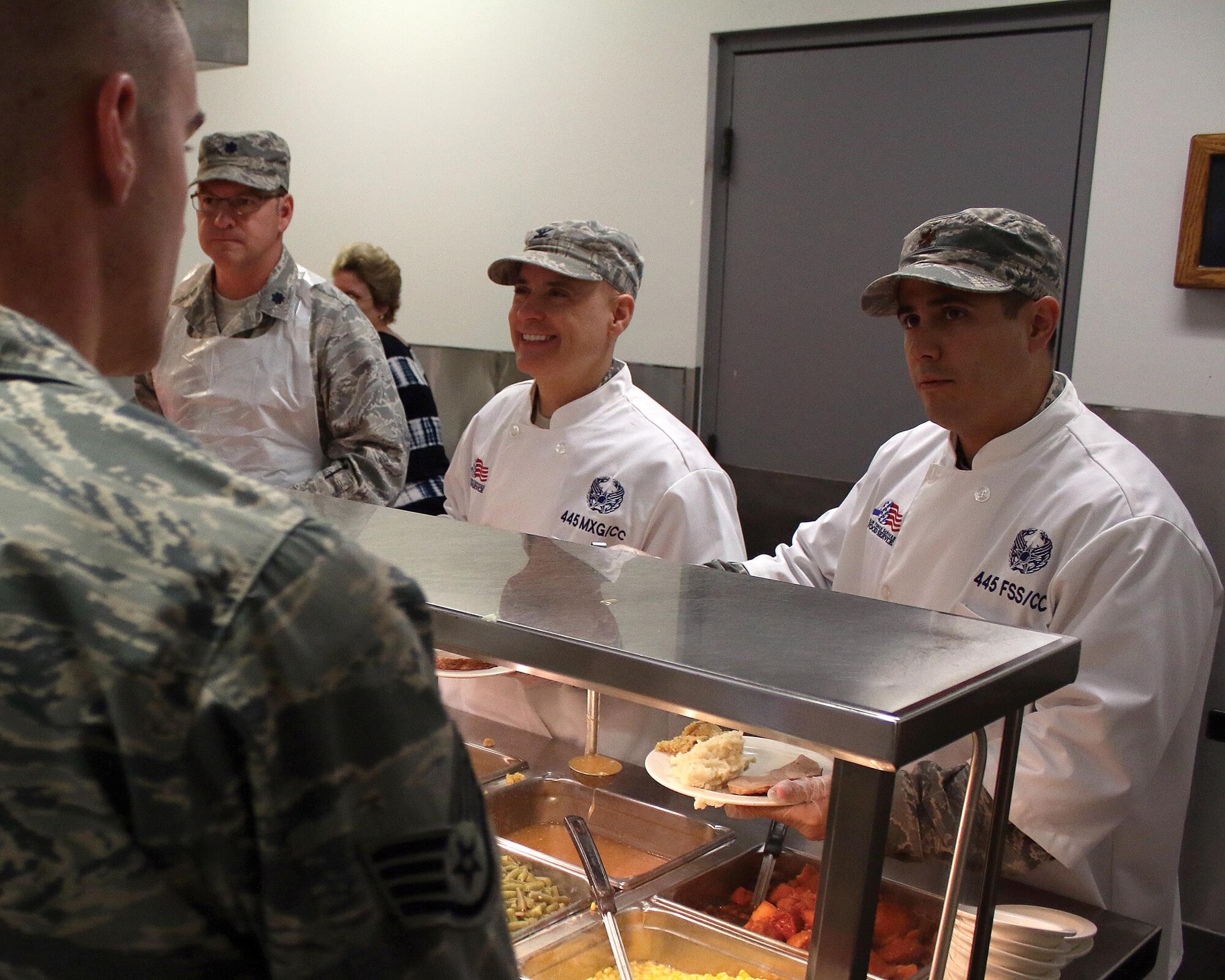 Lt. Col. Todd Reeder, 445th Maintenance Squadron commander; Col.  Cade Gibson, 445th Maintenance Group commander; and Maj. Jason Miller, 445th Force Support Squadron commander, serve holiday meals to Airmen at the Pitsenbarger Dining Facility Nov. 5, 2017.
