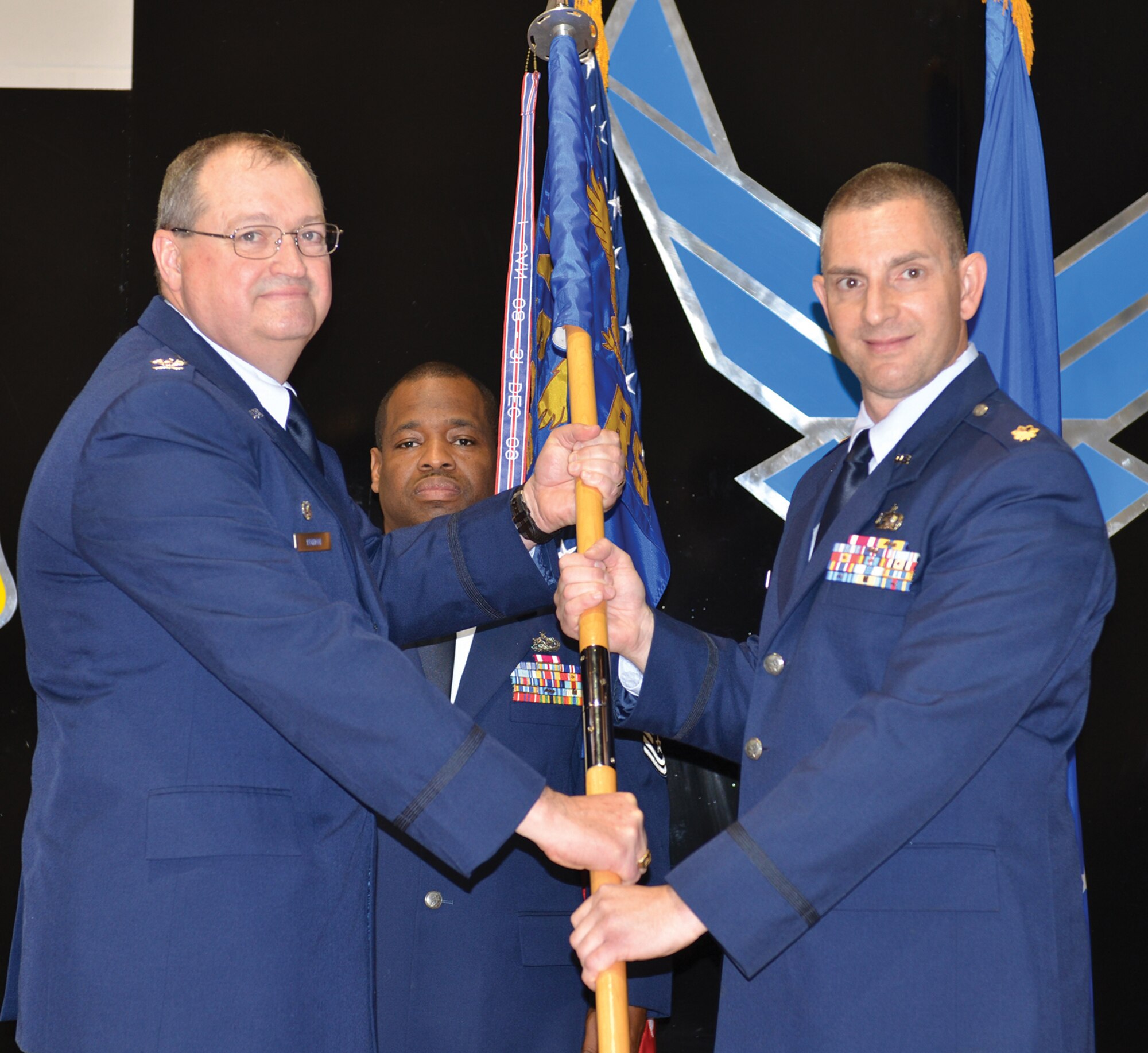 Col. Bryan Runion, 445th Mission Support Group commander, passes the guidon to Maj. Jason Vance, incoming 445th Logistics Readiness Squadron commander at the LRS change of command ceremony, Nov. 5, 2017.