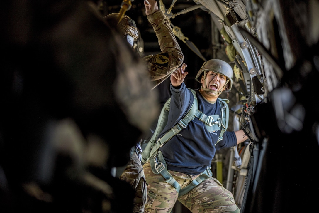A soldier serving as a jumpmaster relays commands during a toy drop operation.