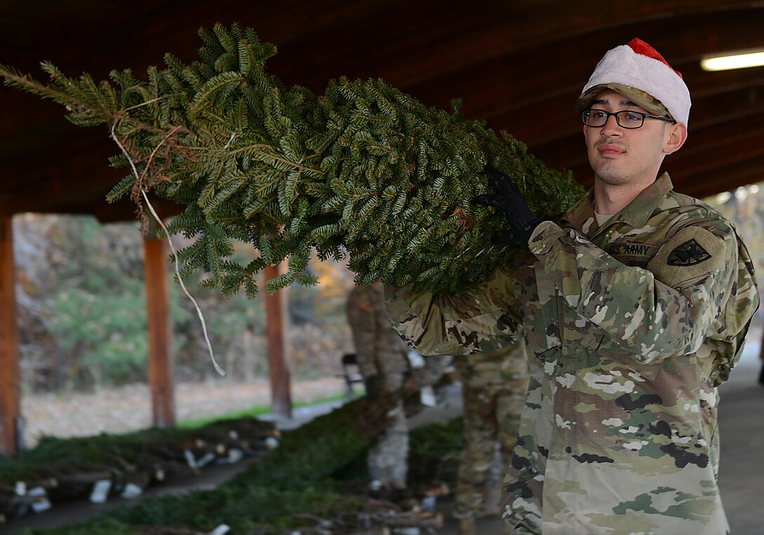 U.S. Army Spc. Michael Moncada, 567th Inland Cargo Transfer Company, 53rd Transportation Battalion, 7th Transportation Brigade (Expeditionary) cargo specialist, carries a live Christmas tree during the Christmas SPIRIT Foundation’s Trees for Troops program at Joint Base Langley-Eustis, Va., Dec. 1, 2017.