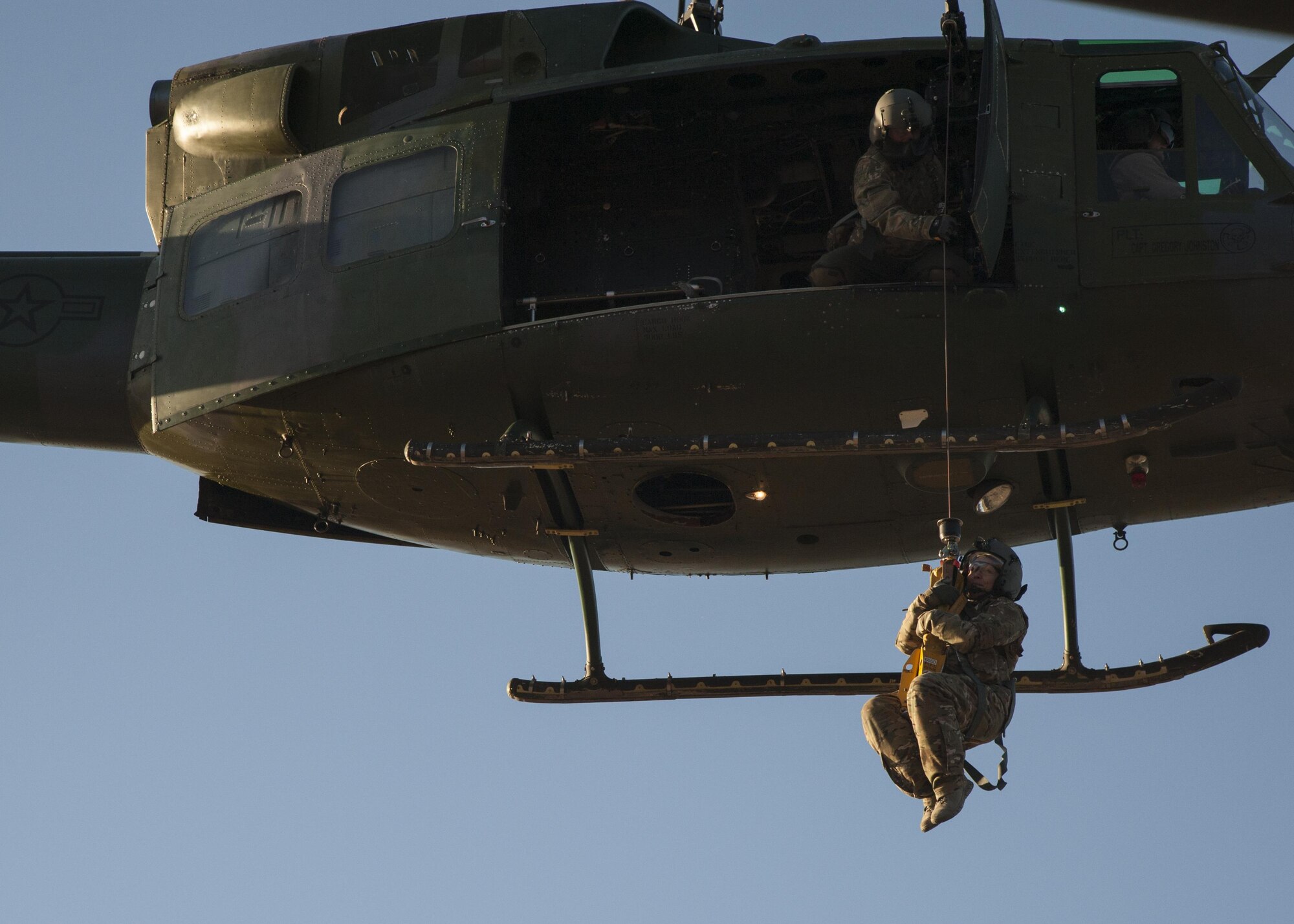 U.S. Air Force Chief Master Sgt. Juliet Gudgel, command chief master sergeant of Air Education and Training Command, is lifted into a UH-1H Huey during a rescue training scenario at Kirtland Air Force Base, N.M., Nov. 27, 2017. On her second day of the visit, Gudgel was able to participate in four training missions with the Airmen of the 58th SOW. (U.S. Air Force photo by Staff Sgt. J.D. Strong II)