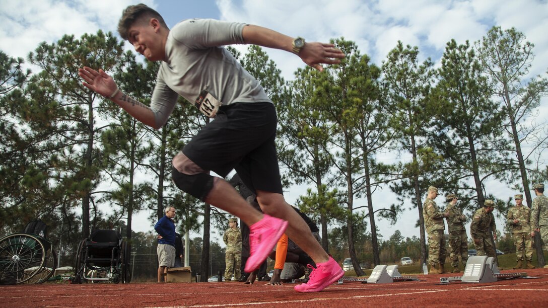 A soldier in pink running shoes practices for a track event.