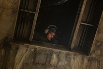 A crewman looks out of a CH-53E Super Stallion to provide ground support by communicating with the pilot during helicopter support team training at Camp Lejeune, N.C., Nov. 21, 2017. The training prepares Marines to provide expedient transportation of gear and supplies to units in locations not suited for ground transportation. (U.S. Marine Corps Photo by Pfc. Heather Atherton)