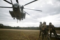 Marines with Combat Logistics Battalion 22 prepare to hook a weighted gear box to a CH-53E Super Stallion for an external lift during helicopter support team training at Camp Lejeune, N.C., Nov. 21, 2017. The training prepares Marines to provide expedient transportation of gear and supplies to units in locations not suited for ground transportation. (U.S. Marine Corps Photo by Pfc. Heather Atherton)