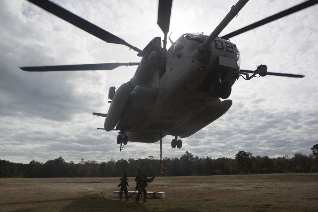 Marines with Combat Logistics Battalion 22 prepare to hook a weighted gear box to a CH-53E Super Stallion for an external lift during helicopter support team training at Camp Lejeune, N.C., Nov. 21, 2017. The training prepares Marines to provide expedient transportation of gear and supplies to units in locations not suited for ground transportation. (U.S. Marine Corps Photo by Pfc. Heather Atherton)