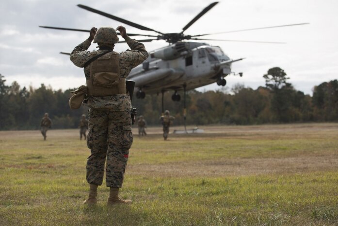 Marines with Combat Logistics Battalion 22 prepare to hook a weighted gear box to a CH-53E Super Stallion for an external lift during helicopter support team training at Camp Lejeune, N.C., Nov. 21, 2017. The training prepares Marines to provide expedient transportation of gear and supplies to units in locations not suited for ground transportation. (U.S. Marine Corps Photo by Pfc. Heather Atherton)