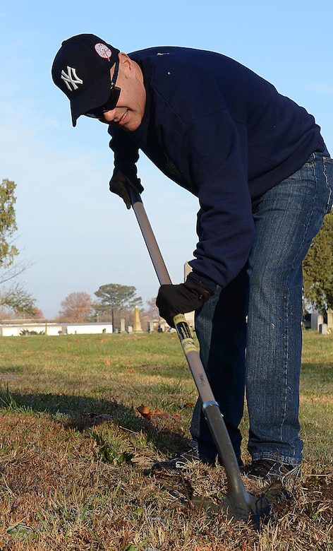 U.S. Army Command Sgt. Maj. Eric Vidal, 733rd Mission Support Group command sergeant major, clears grass from a grave during a restoration project at Pleasant Shade Cemetery in Hampton, Va. Dec. 2, 2017.
