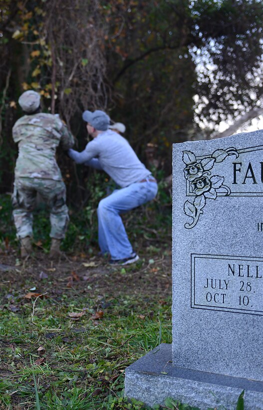 U.S. Army Soldiers from the Better Options for Single Soldiers program at Joint Base Langley-Eustis, Va., pull vines from a tree during a restoration project at Pleasant Shade Cemetery in Hampton, Va. Dec. 2, 2017.