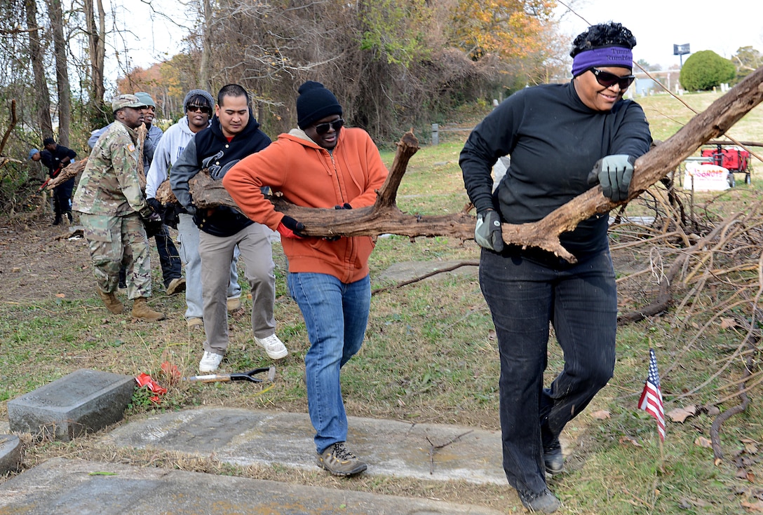 U.S. military and civilian community volunteers remove a tree limb during a restoration project at Pleasant Shade Cemetery in Hampton, Va. Dec. 2, 2017.