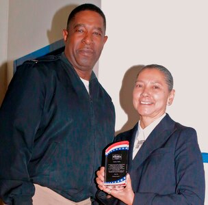 IMAGE: DAHLGREN, Va. (Nov. 21, 2017) - Capt. Godfrey "Gus" Weekes, Naval Surface Warfare Center Dahlgren Division (NSWCDD) commanding officer, presents a plaque to Juanita Mullen - Veterans Administration’s Liaison for American Indian and Alaska Native Veterans - at the NSWCDD sponsored National American Indian Heritage and Veterans-Military Families Month Observance. “Indians have fought for the U.S. armed forces at a higher rate per capita than any other racial group in the country,” said Mullen. “For many, military service was an economic opportunity in a world that threw up racial barriers to gainful employment for people of color. It was also a way to continue ancient warrior traditions and earn respect from the people at home as well as others who often had little respect for Indians.” (U.S. Navy photo by Patrick Dunn/Released)