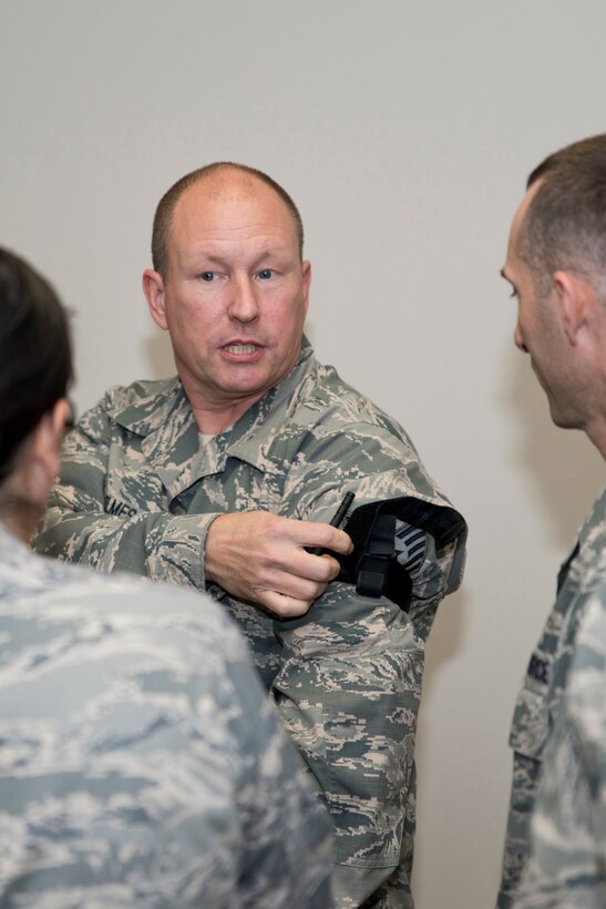 U.S. Air Force Reserve Tech Sgt. Christopher Holmes, aircraft electrician, 913th Maintenance Squadron,                 instructs Airmen how to apply a tourniquet to themselves under combat conditions during Self-Aid Buddy Care (SABC) Hands-On training Dec. 2, 2017, at Little Rock Air Force Base, Ark.