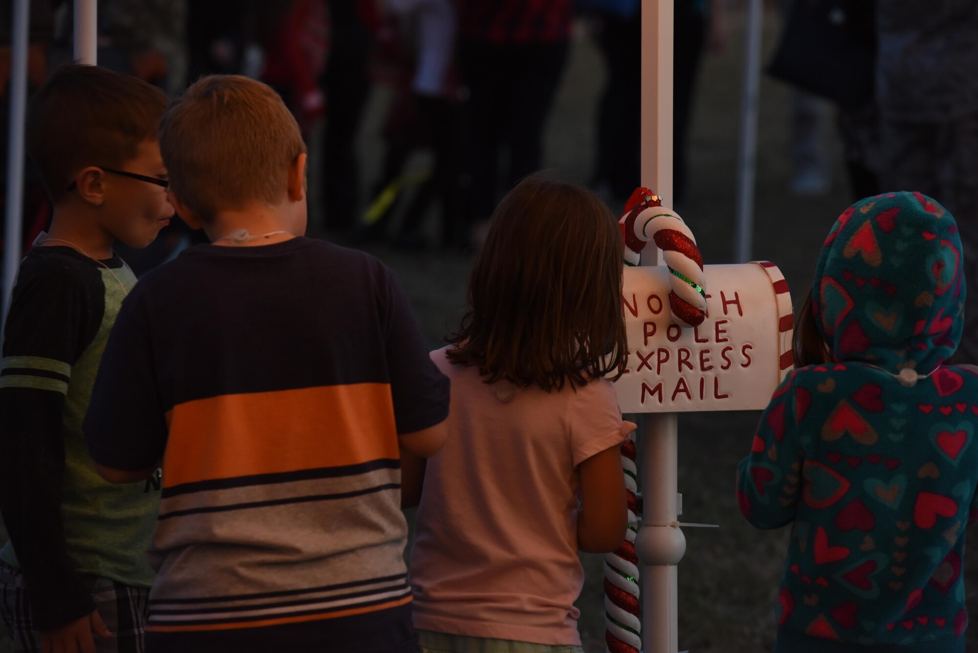 Children play with a mailbox for taking letters to Santa Claus as they wait for Santa to visit during the Tree Lighting Ceremony at the Parade Field on Goodfellow Air Force Base, Texas, Dec. 4, 2017. Once Santa arrived, children could get their pictures taken with him and tell him what they want for Christmas.